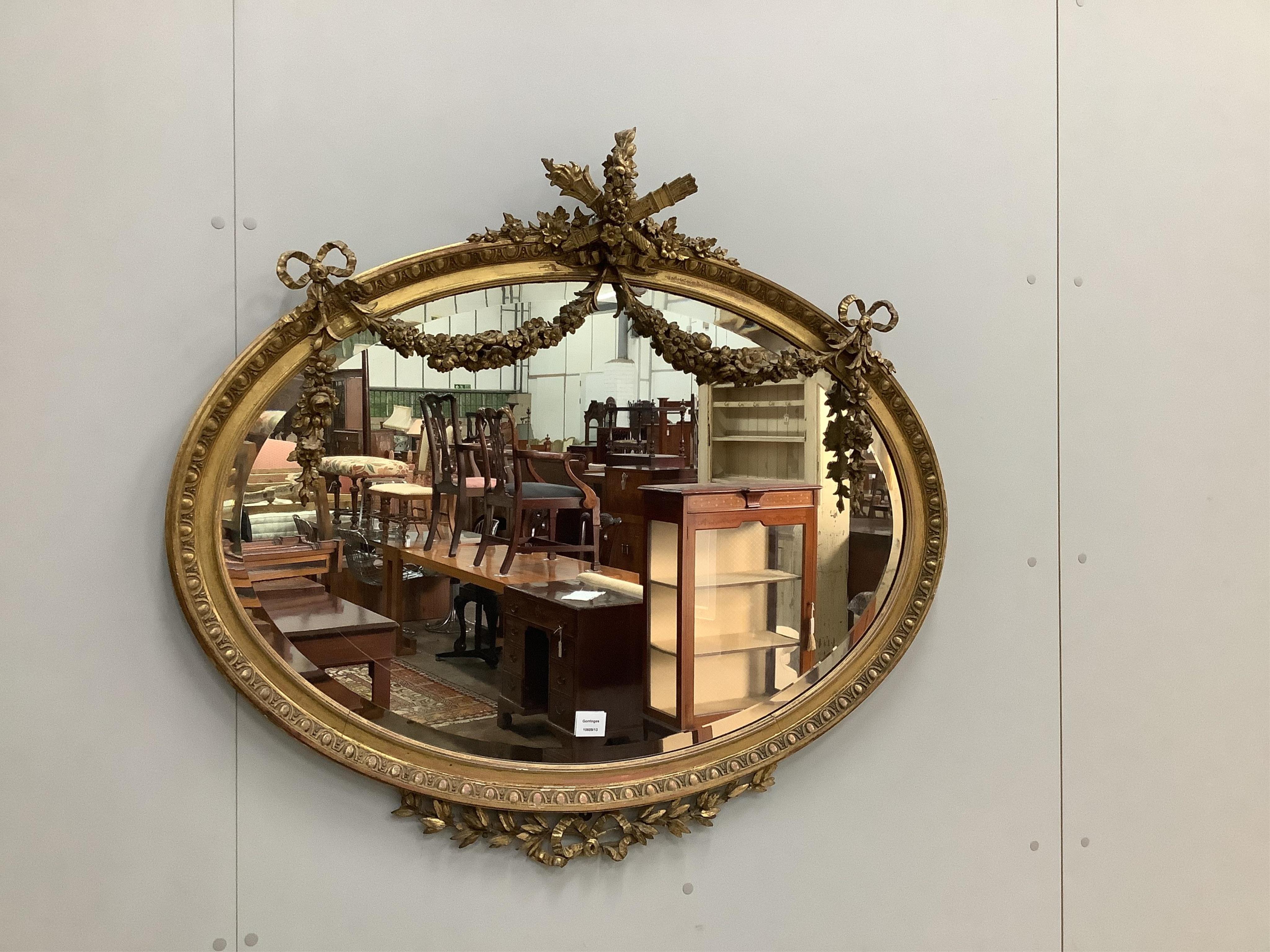 An Edwardian oval giltwood and composition wall mirror, width 105cm, height 95cm. Condition - fair to good